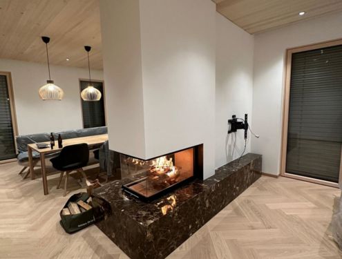 So ein moderner Ofen mit Natursteinsockel, Holznische und seinem dreiseitigem Sichtfenster ist ein wahres Highlight in jedem Wohnbereich.