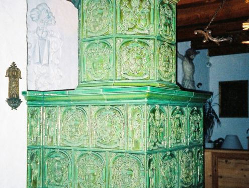 Traditioneller Kachelofen in grün mit Wappen