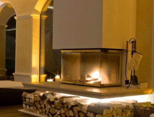 Moderner Ofen mit Sockel für Brennholz mit LED-Beleuchtung und dreiseitigem Sichtfenster