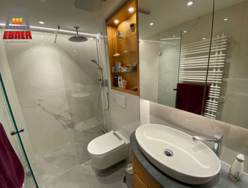 Ein weiteres Badezimmer mit Marmoroptik-Fliesen in Großformat. Das kleine, aber feine Badezimmer wirkt dadurch hell, modern und mit der richtigen Beleuchtung auch etwas größer.